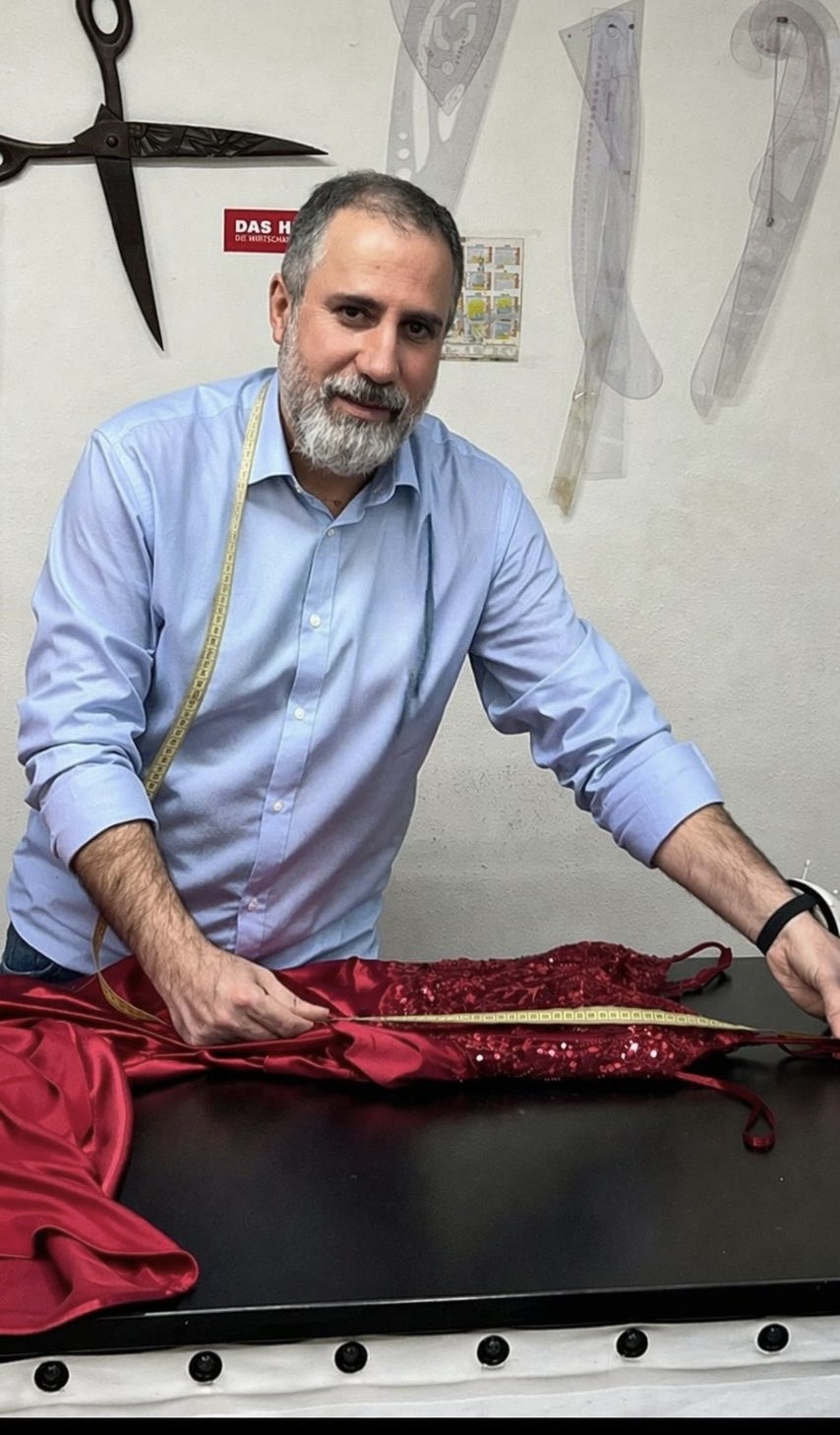 Inhaber von Amiriko bei der Arbeit an einem festlichen Kleid